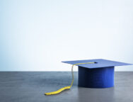 Blue graduation cap on wooden table