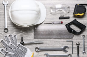 Set of construction tools on light wooden background